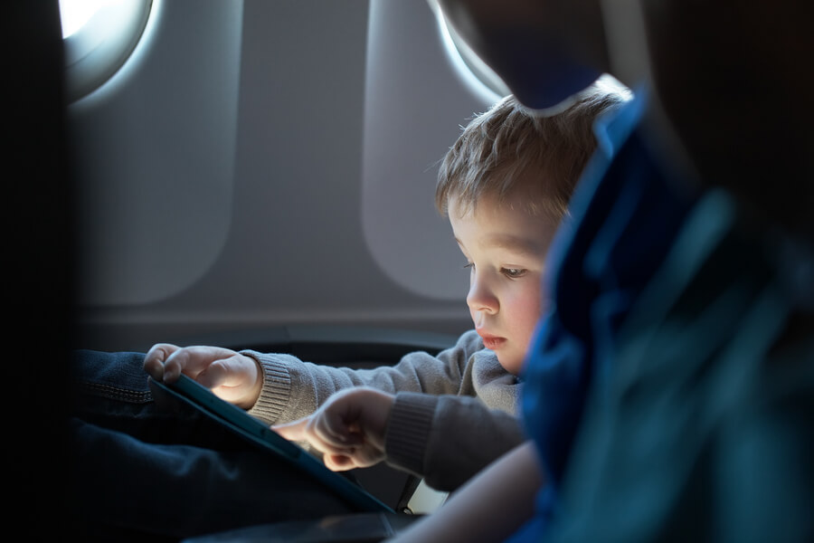 toddler with tablet on flight