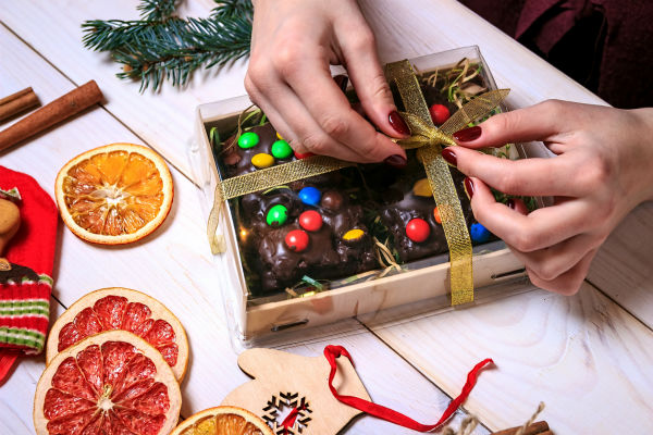 woman wrapping diy christmas gift of chocolate