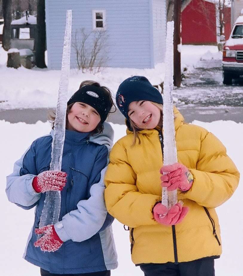 Two Girls Holding Giant Icicles