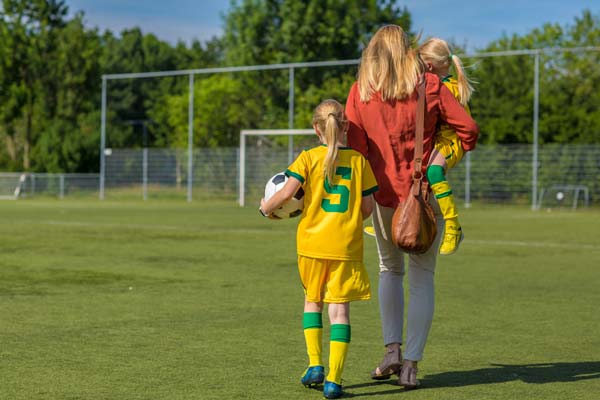mom and daughters on soccer field
