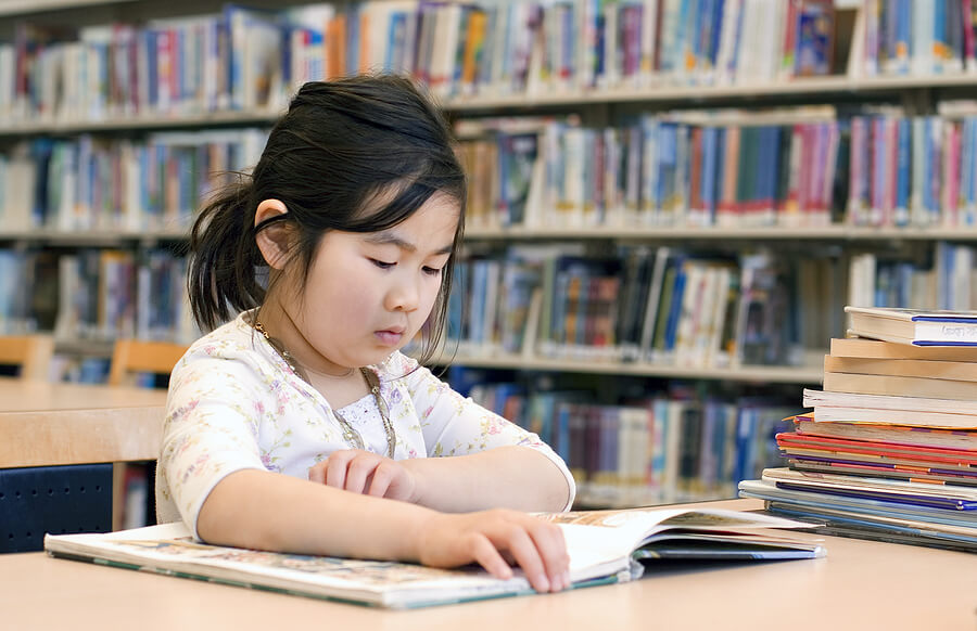 StrugglinginSchool,ThirdGradeGirlReadingBookinLibrary