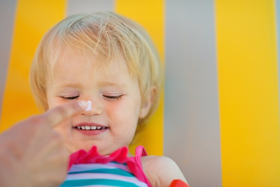 Applying sunscreen to toddler nose