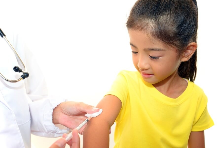 Asian girl getting vaccinated at doctors office