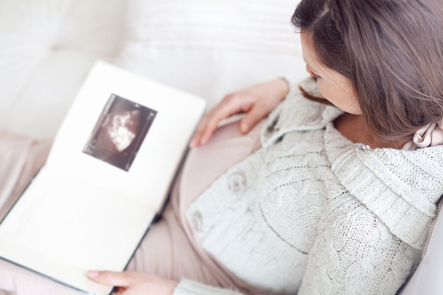 Top view of pregnant woman looking at ultrasound