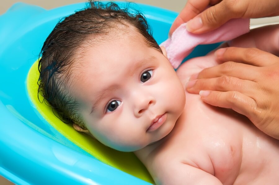 Baby in bath with wash cloth
