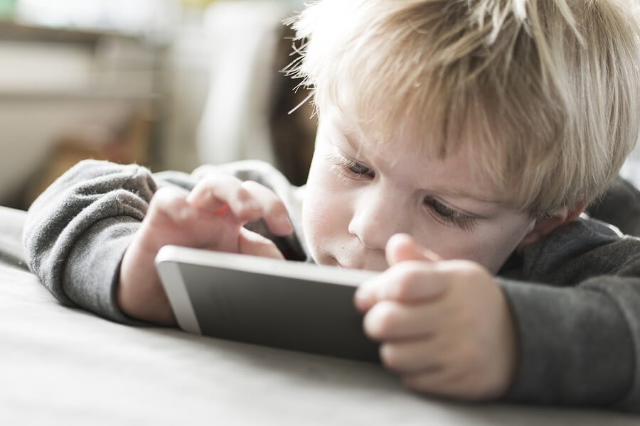 Young blond boy using smartphone