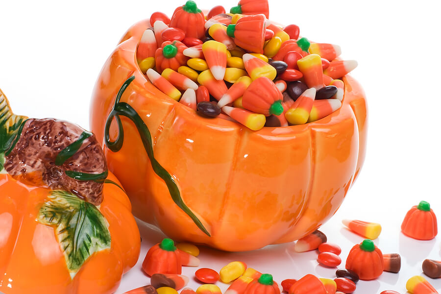Halloween candy leftovers, bowl of Halloween candy corn and pumpkins