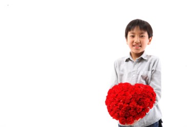 Young Asian boy with rose bouquet against white back drop