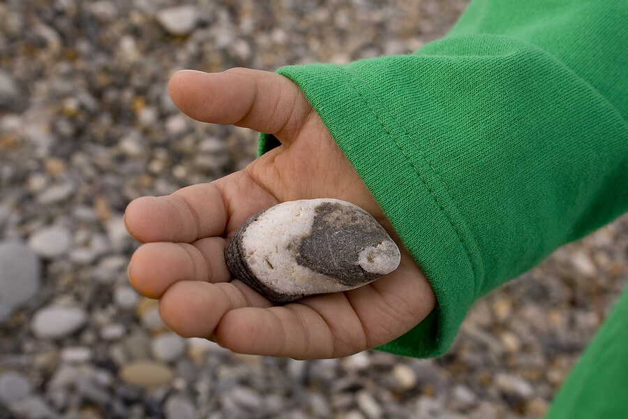 Summer Science for Kids, Young child holding stone to learn about geology