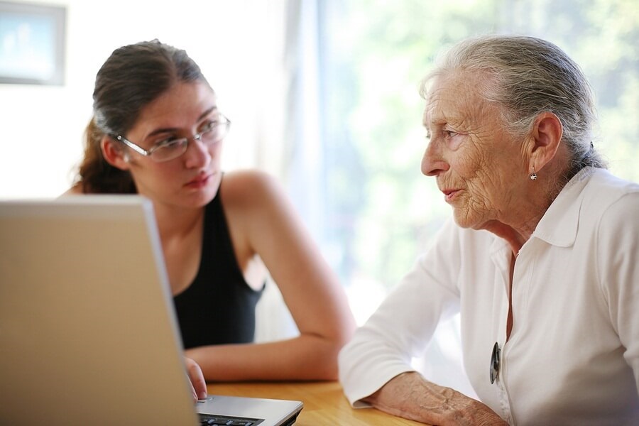 Young girl and elderly woman on the computer