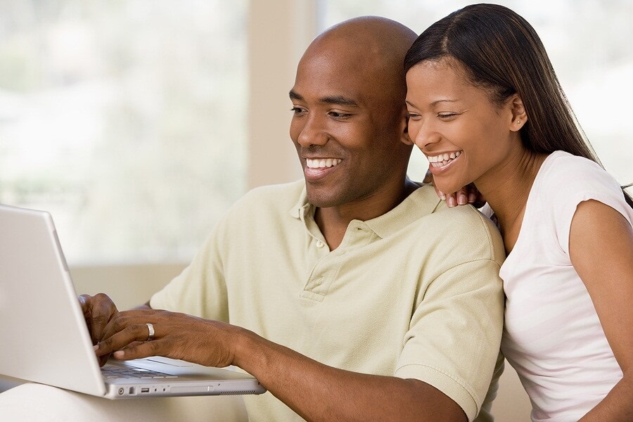 Young couple laughing over laptop