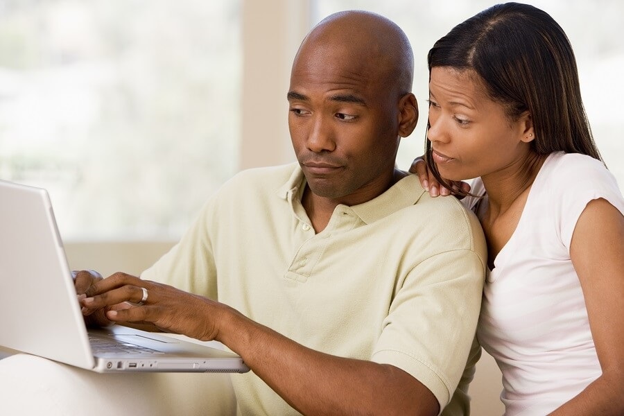 Couple looking annoyed on laptop