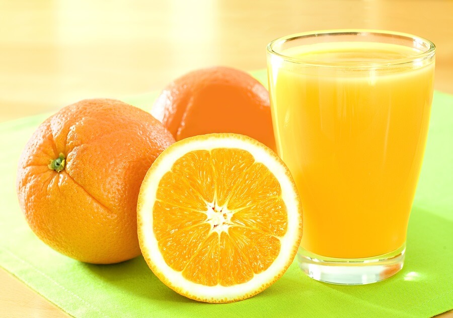 Cut oranges and glass of orange juice