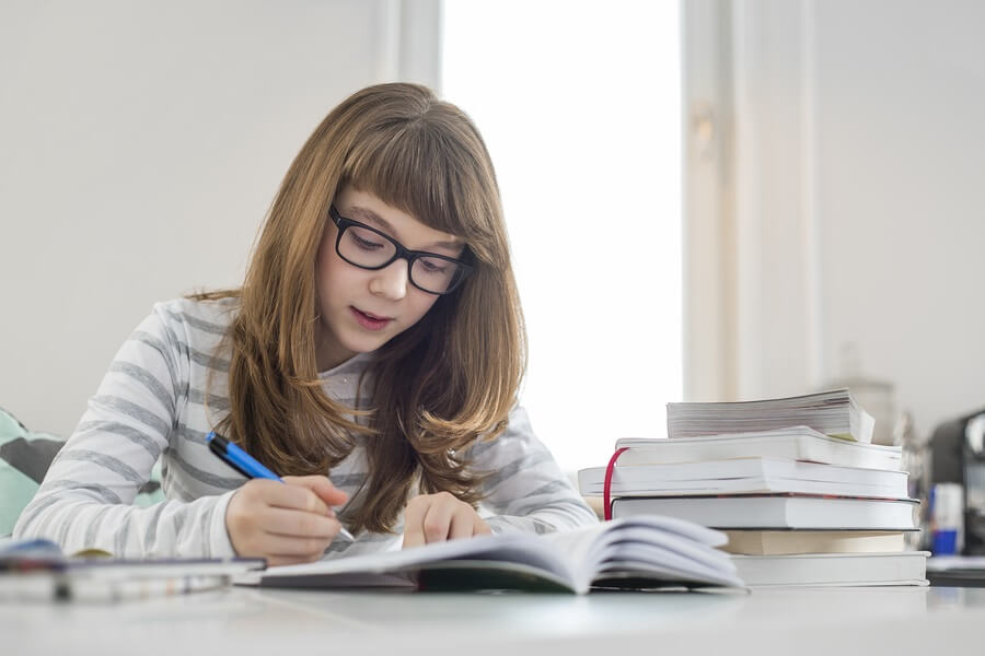Girl with Glasses Doing Homework