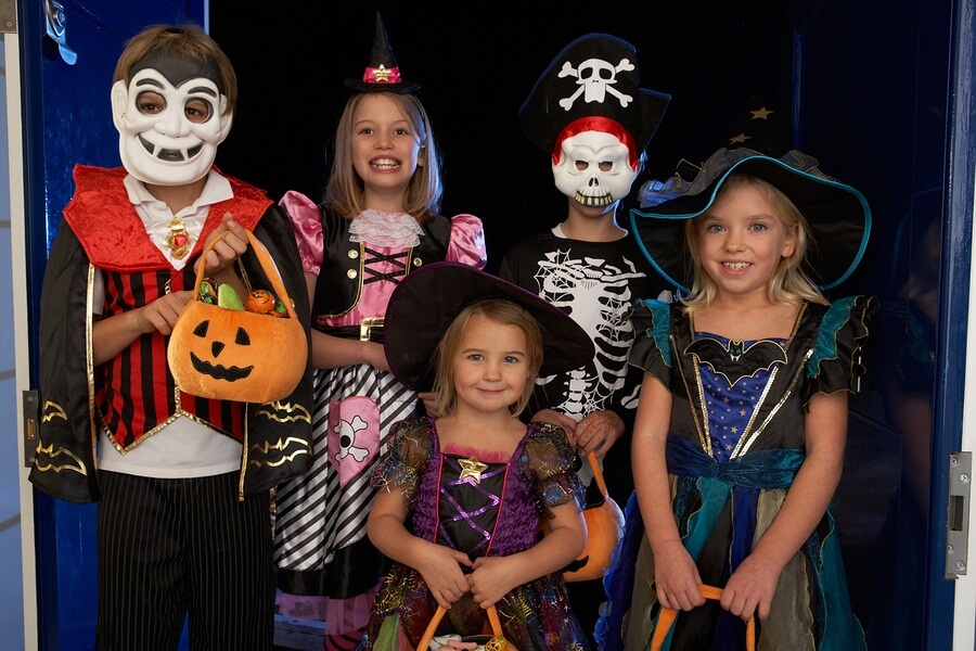 Group of kids dressed up and trick or treating on Halloween