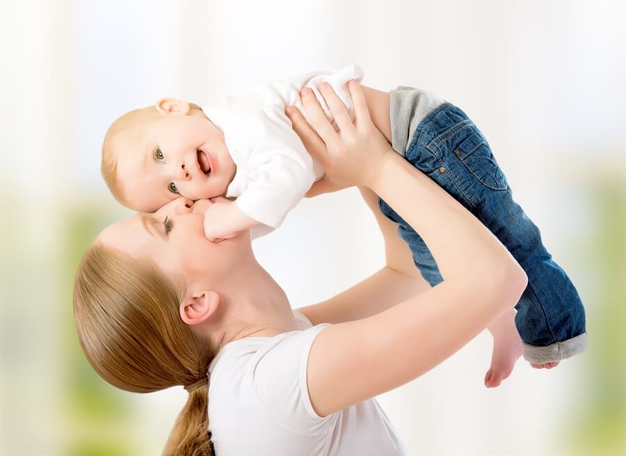 Happy mom swinging happy baby in air