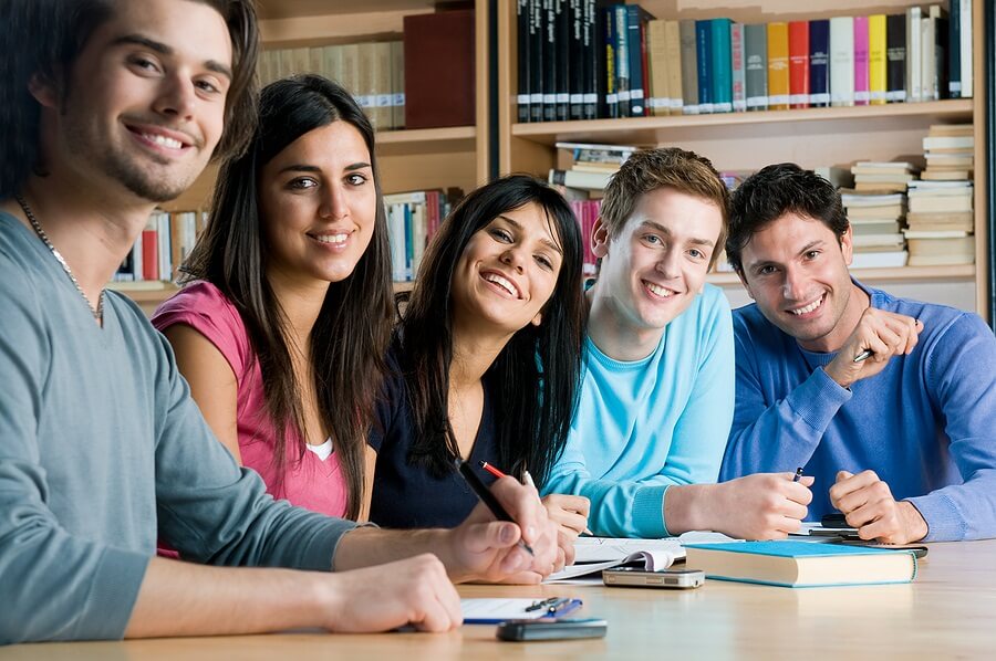 Group of happy students sitting around a table