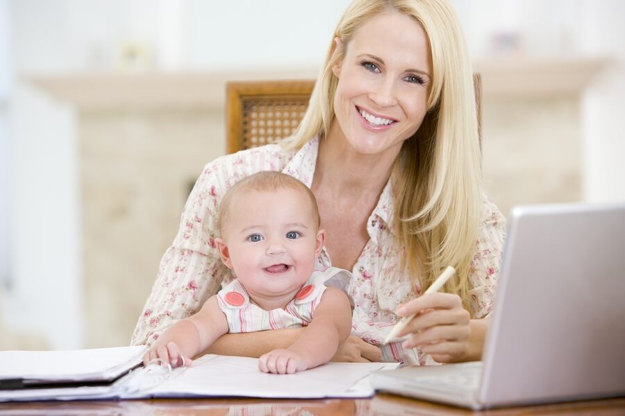 Happy working mother with smiling baby on lap