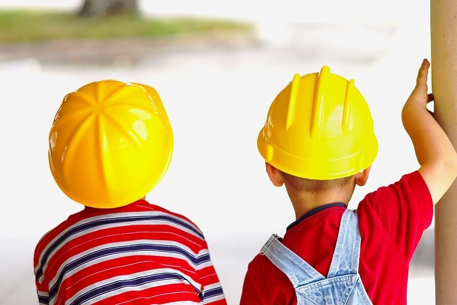 Two young boys in yellow construction hats