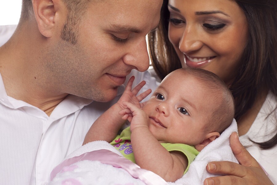 Smiling New Parents Holding Newborn Baby