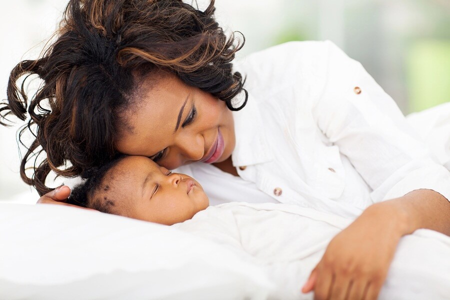 Mom watching newborn baby sleep