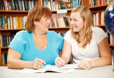 Mother and teenage daughter looking at each other and smiling