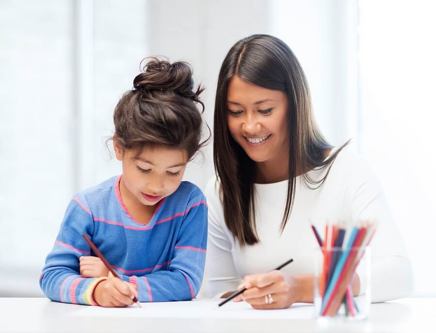 Mother Helping Daughter with Homework in Kitchen