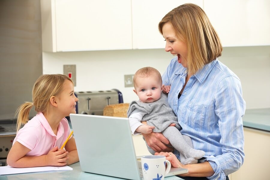 Mom and kids in kitchen on computer