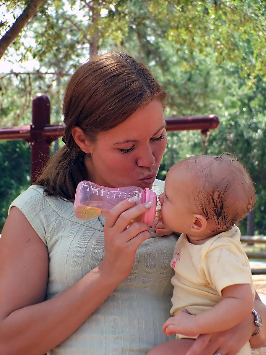 Mother bottle feeding baby