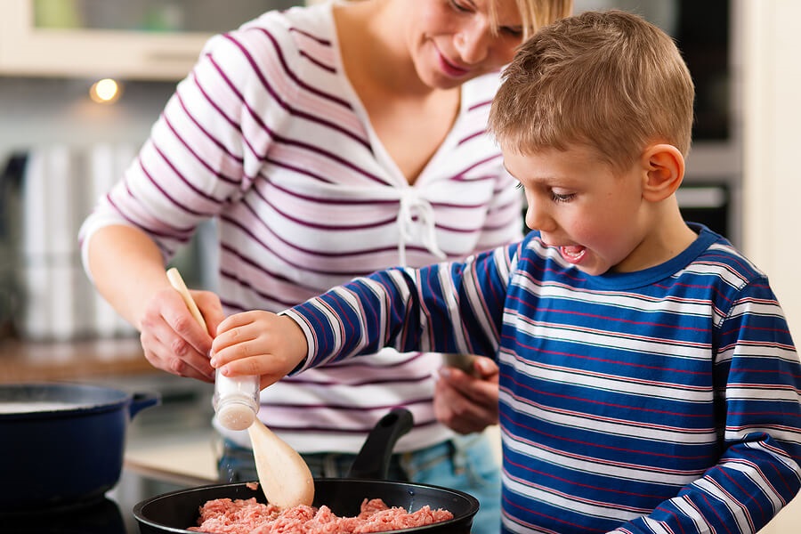 Mother and son cooking together in kitchen