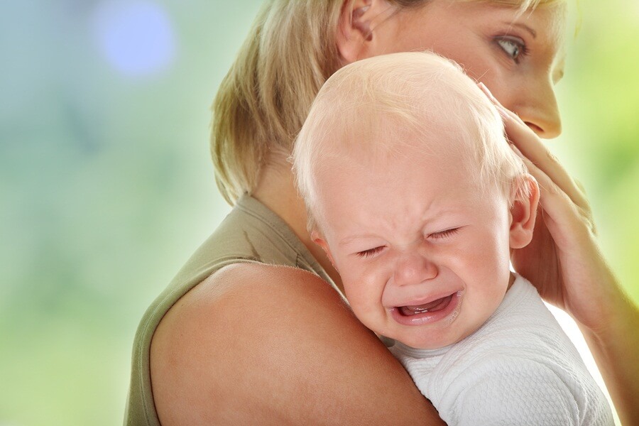 Stressed mom holding crying baby