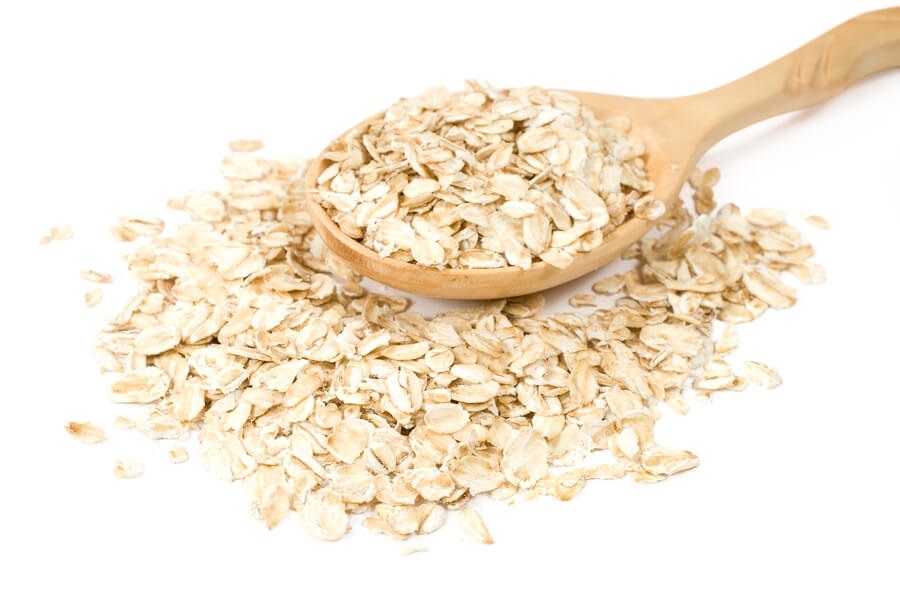 Spoonful of oats on white background