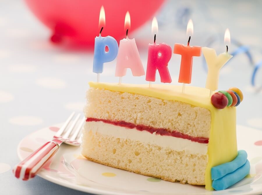 Slice of birthday cake with party candles