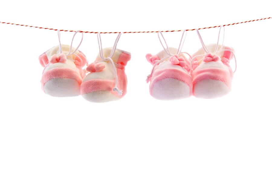 Pink booties on clothesline against white background