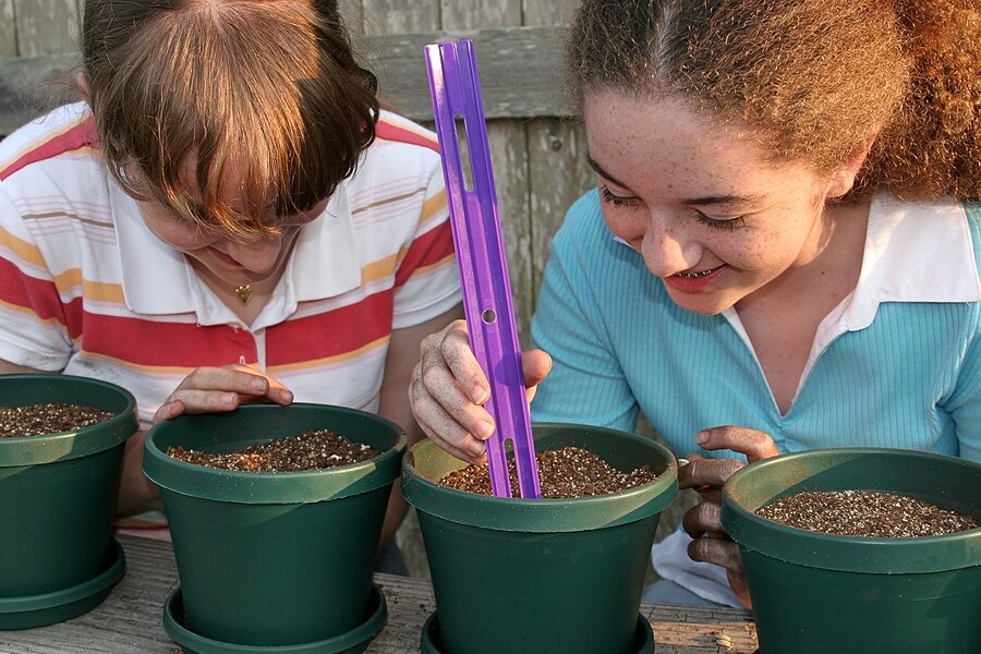 Two young girls planting seeds in pots