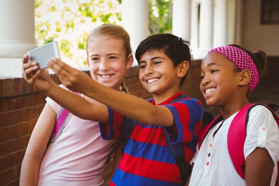 School friends taking selfie with smartphone