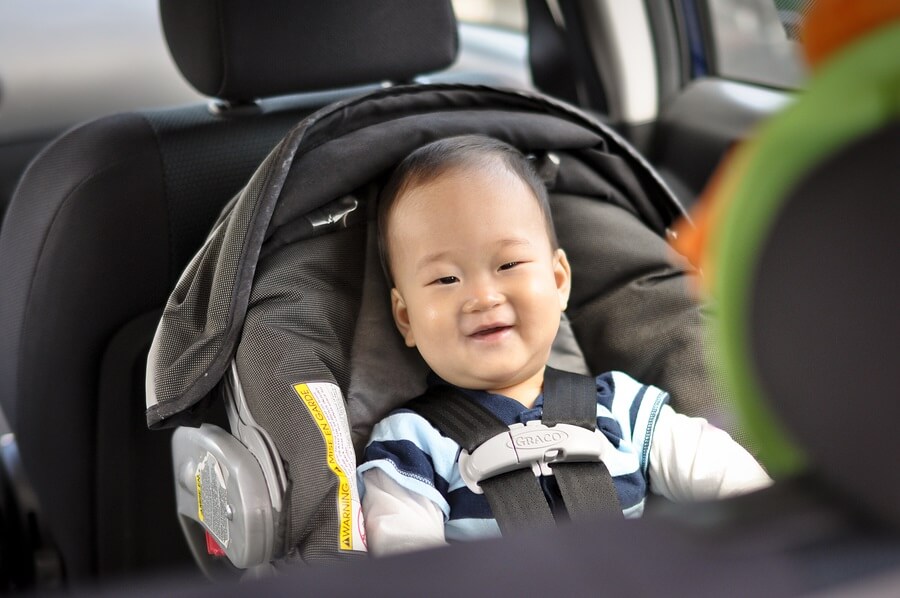 Smiling baby sitting in car seat