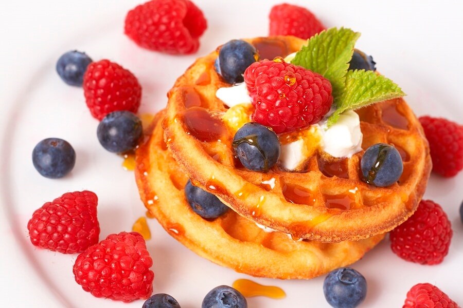 Stack of waffles with fruit and syrup