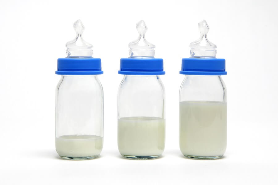 Line of baby bottles on white background