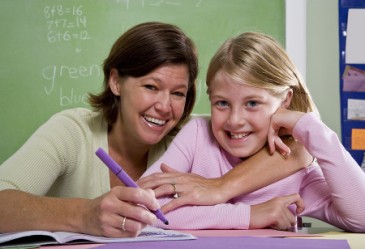 Smiling teacher and student in classroom