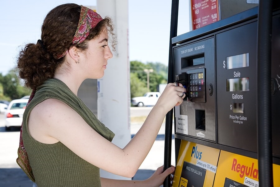 Teen paying for gas at pump with credit card