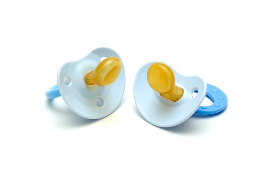 Two blue pacifiers against white background