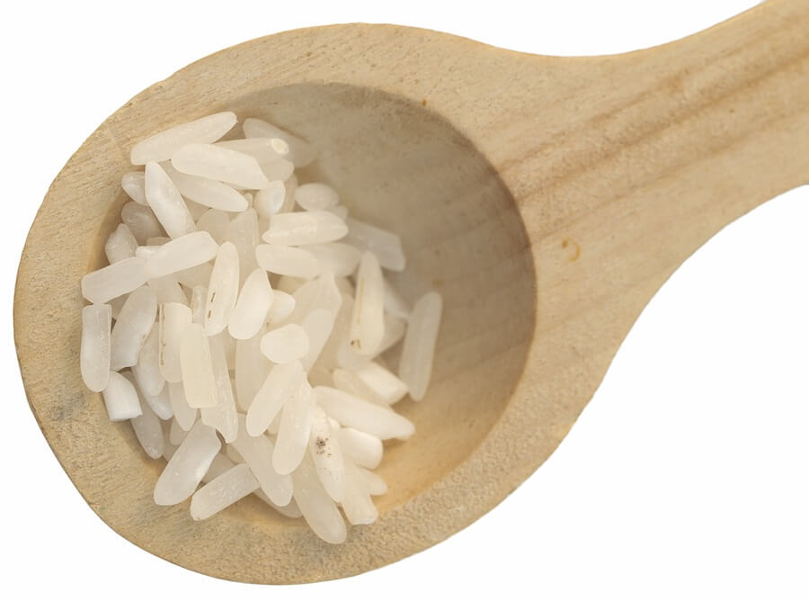 Close up of white rice in wooden spoon