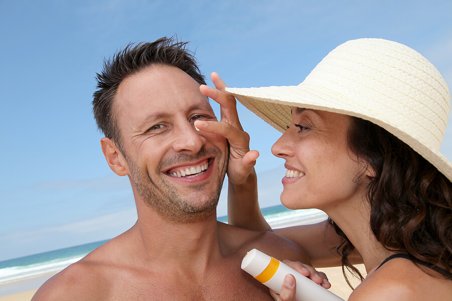 Keeping Your Husband Healthy, Woman putting sunscreen on man for cancer prevention
