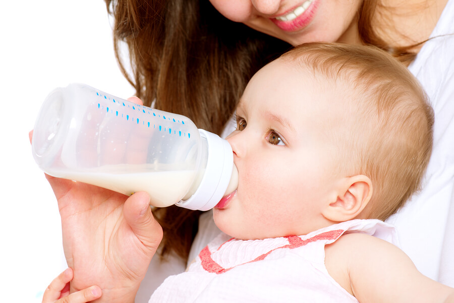 baby drinking bottle of formula