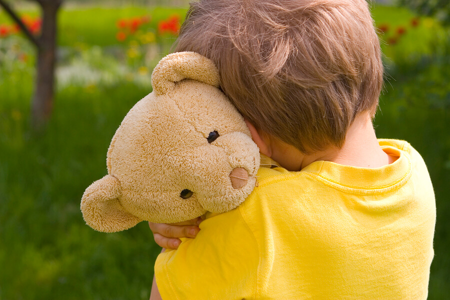 sensitive boy hugging bear