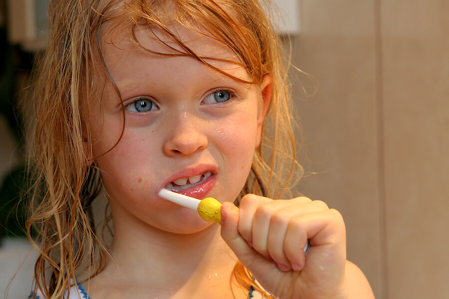 Summer camp essentials, girl brushing teeth with toothbrush