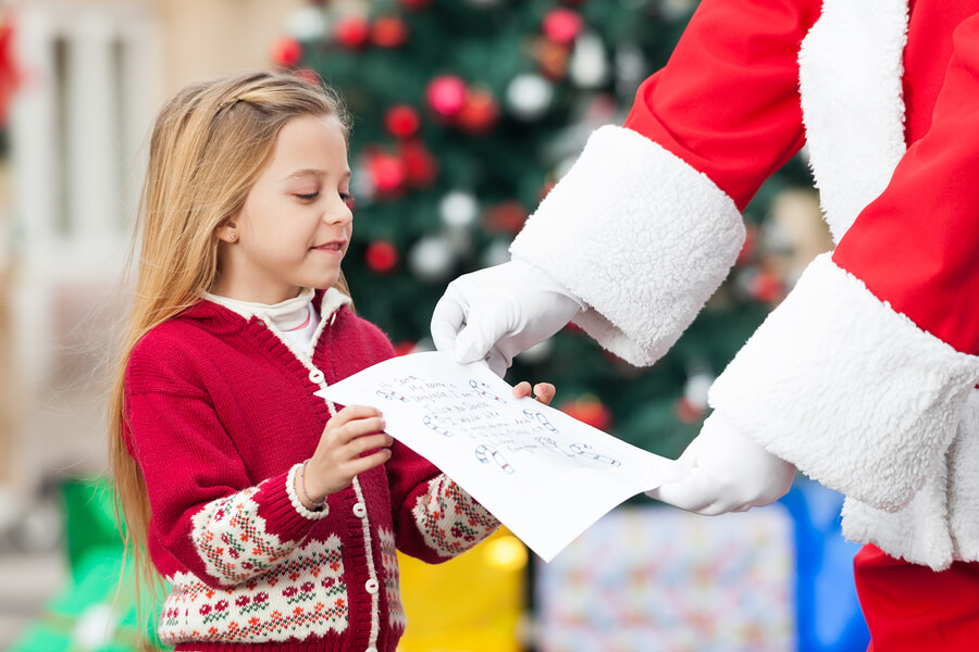 child giving letter to Santa