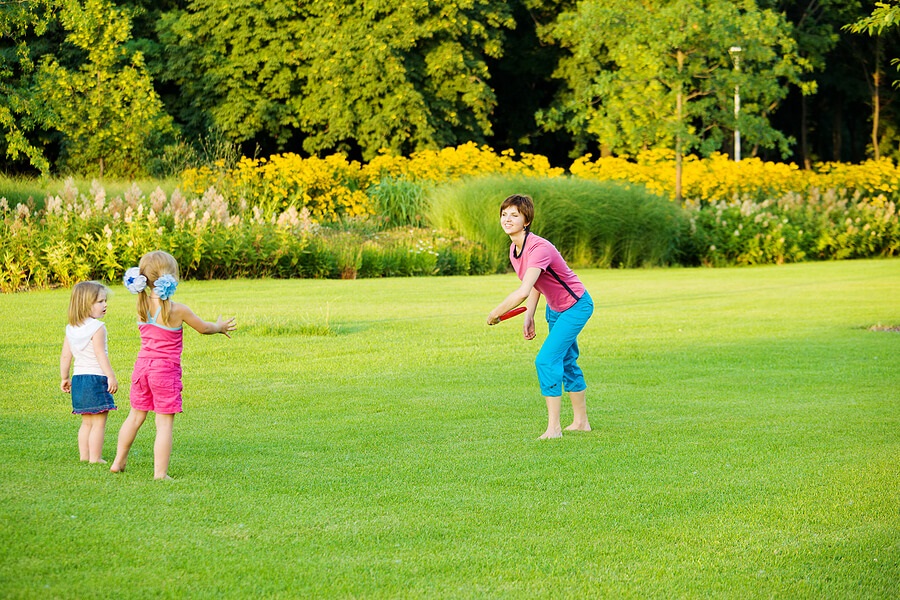 Fun Family Fitness, Mom throwing frisbee to kids outside
