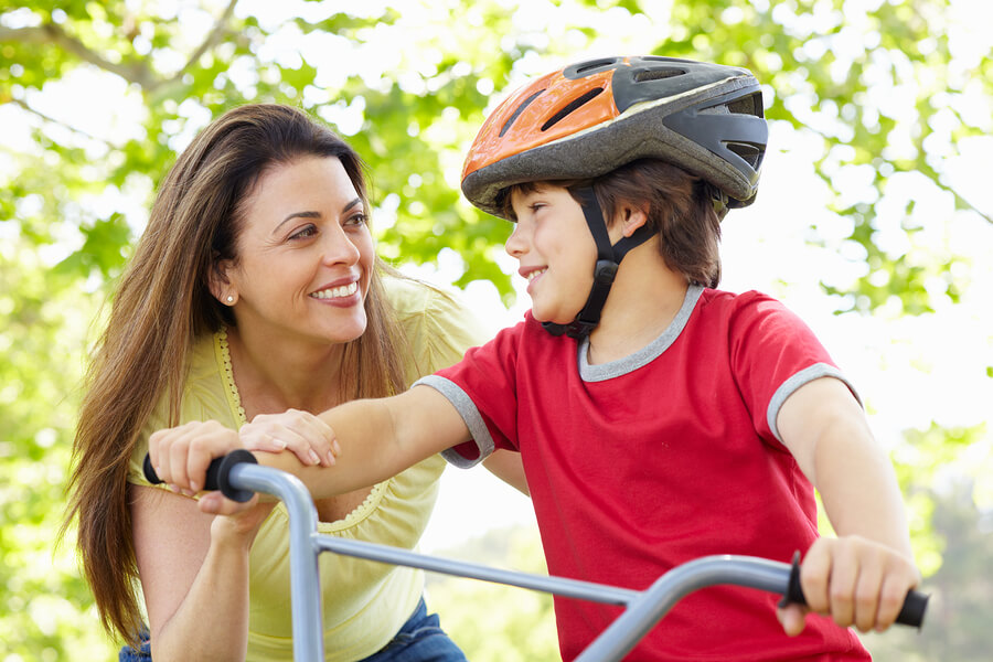 mother helping son ride bike